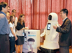 Haizhou Li (right) introduces the capabilities of OLIVIA—Singapore’s first social robot